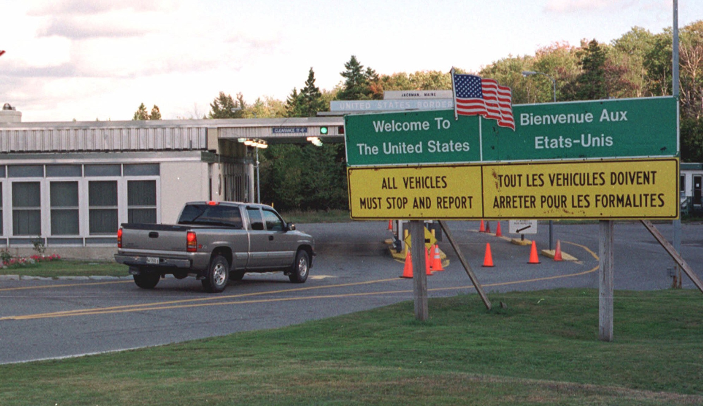 a silver pickup truck driving into a United States-Canadian customs facility