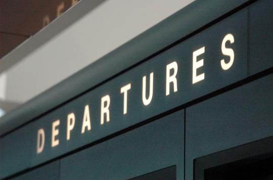 Close-up of airport departures sign.