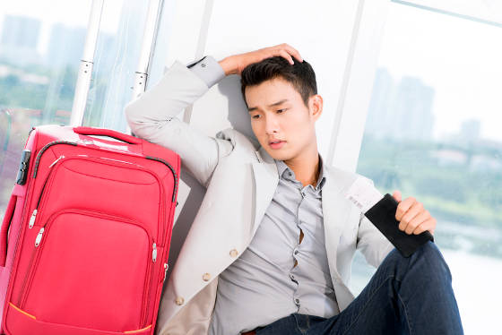 Young man at airport with boarding pass and passport