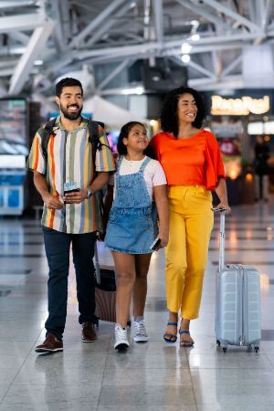 a family walking through an airport together with passports