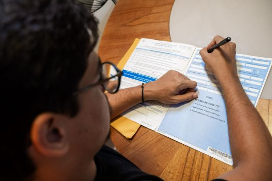 Man filling out a passport application at a table