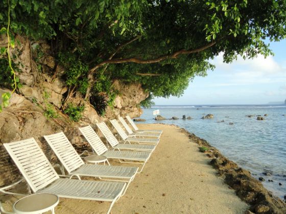 Beach chairs on a guam beach under tree cover