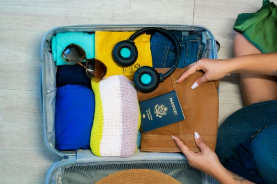 a suitcase being packed with clothes, accessories, and a passport