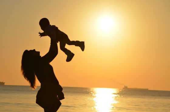 A mother and baby on a beach in mexico at sunset