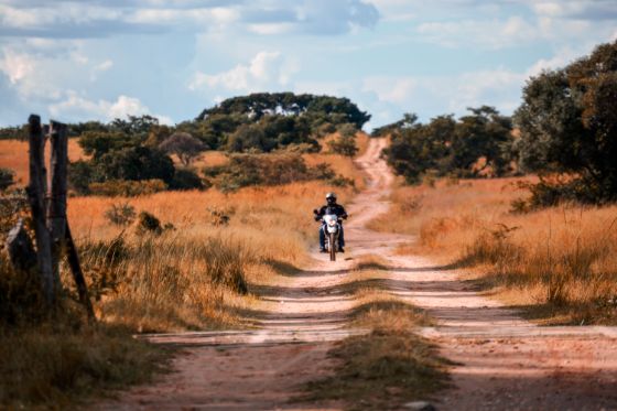 a motorcycles rider on a Zimbabwe farm road
