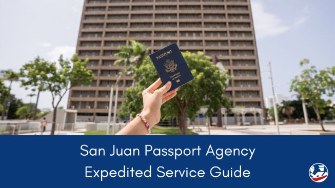 A new passport held up in front of the entrance to the San Juan Passport Agency building
