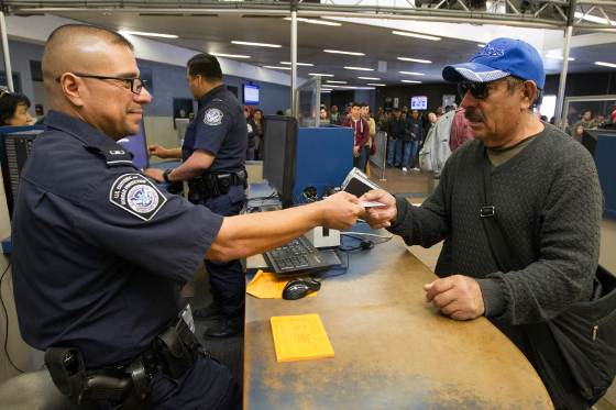 A CBP agent checks a passport at the US Mexico border