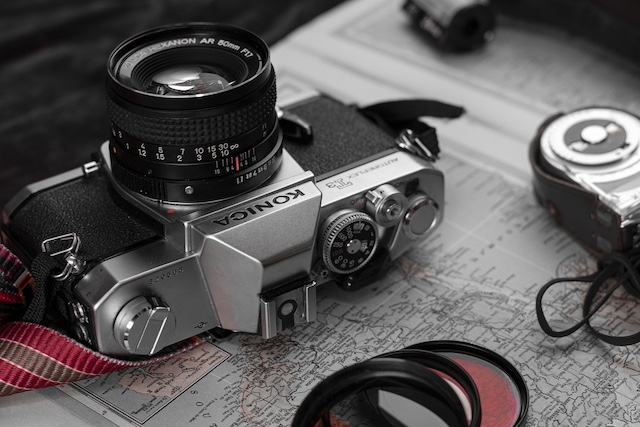 konica camera on wooden table.