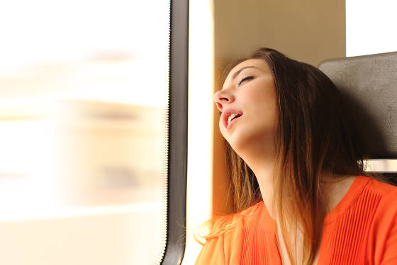 Teenage girl sleeping on train due to jet lag.