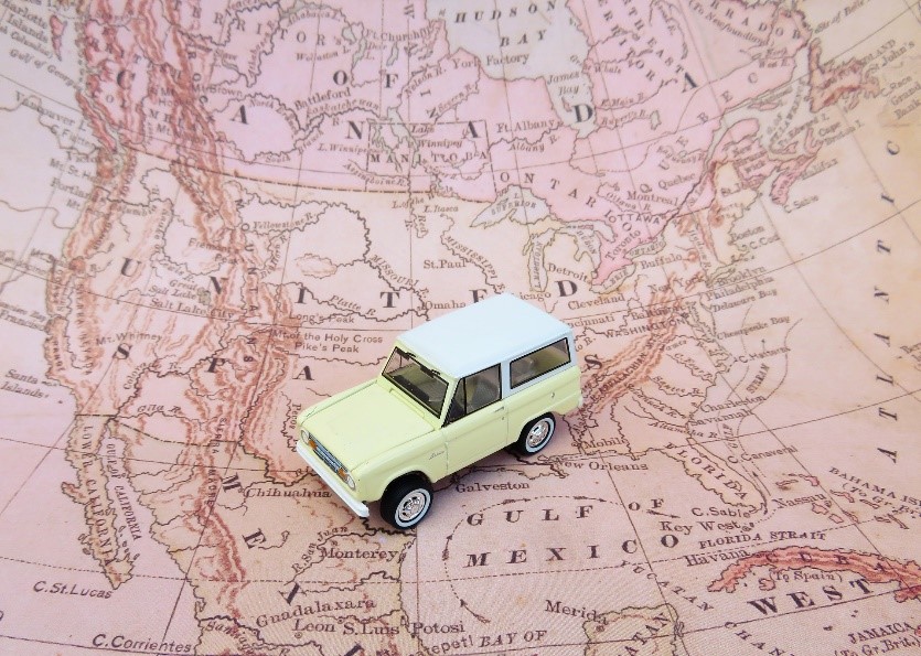 a yellow toy SUV on a map of North America