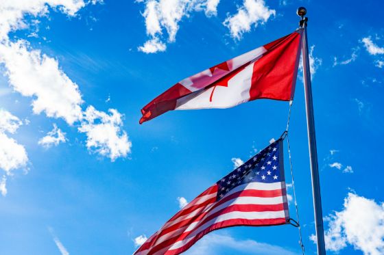 An American and Canadian flag on the same pole