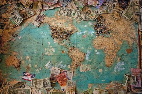 world map with pins and currency