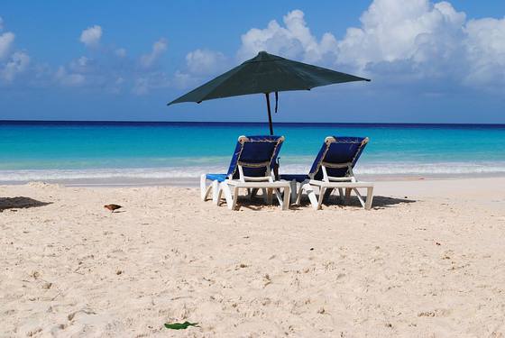Two chairs and umbrella on beautiful Barbados beach.