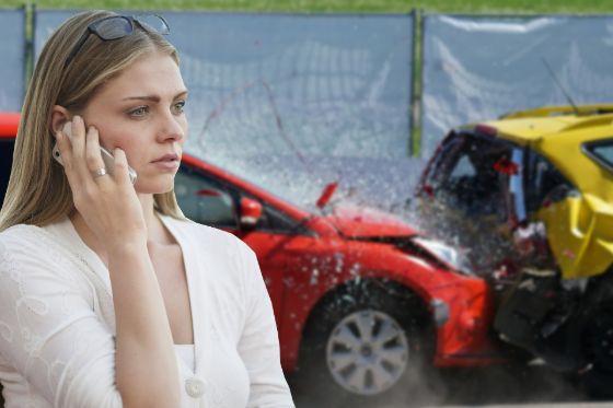 Young woman making a phone call after a car crash