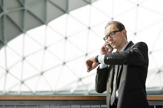 Businessman looking at watch while waiting for international flight