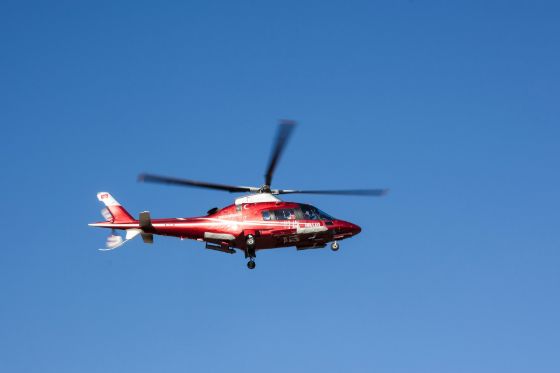 a rescue helicopter flying in blue sky