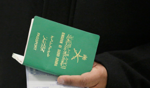 hand holding green saudi passport and document