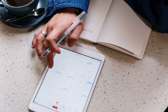 A person checking a calendar on a tablet