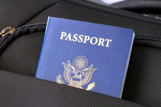 US passport sticking out of a black barryon bag