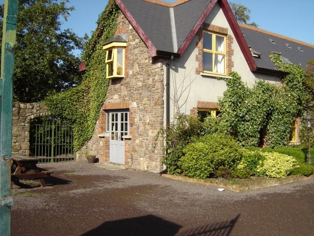 A charming two-story Irish house with lots of plants in yard. Ireland House