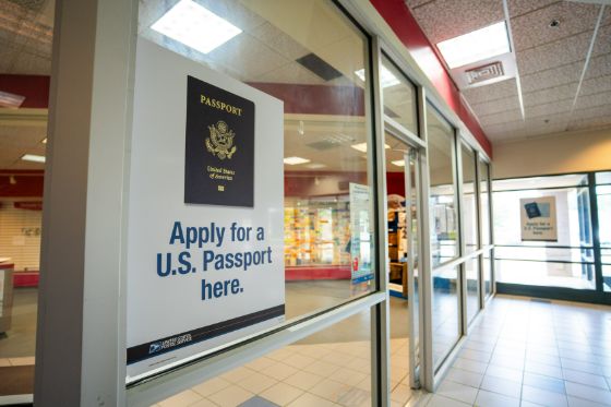 A sign in a United States Post Office window indicating it is a passport application facility.